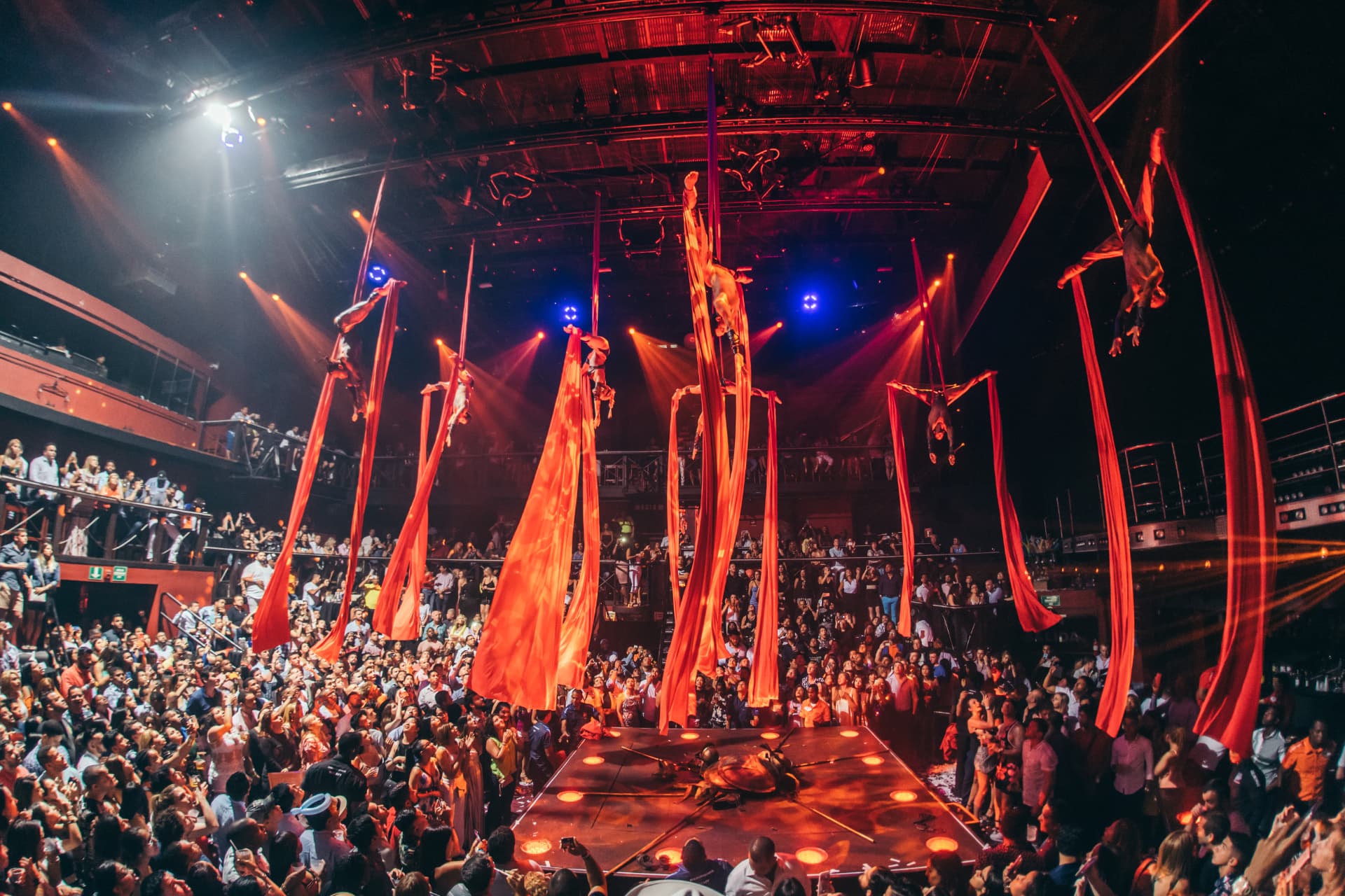 Acrobatas em tecidos vermelhos sobre a pista do CocoBongo